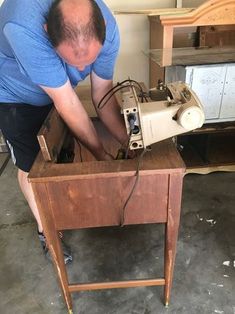 a man working on an old sewing machine