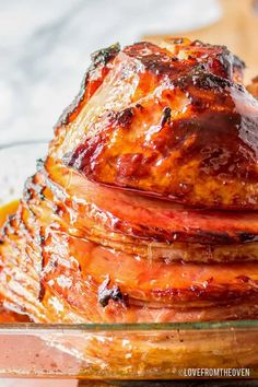 a pile of cooked meat sitting on top of a glass plate covered in bbq sauce