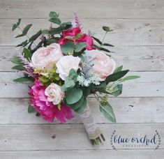 a bridal bouquet with pink roses and greenery on a white wooden background,