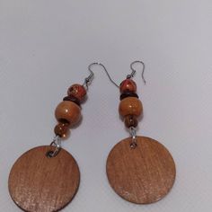 the earrings are made with wood and glass beaded on each earring, which has a wooden disc attached to it