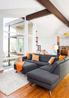 a living room filled with furniture and a large window next to a wooden floor covered in lots of windows