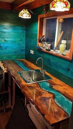 a kitchen counter made out of wood with blue paint on the top and bottom half