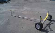 a wheelbarrow with two yellow bars attached to it in an empty parking lot