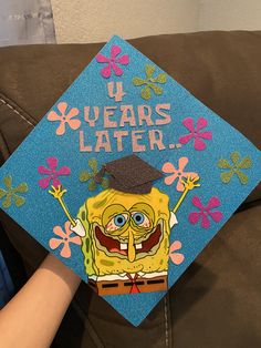 a blue graduation cap decorated with an image of spongebob and the words u years later