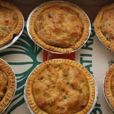 six pies sitting on top of a green and white table cloth