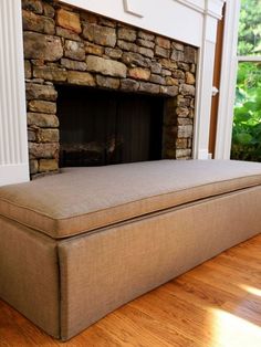 a couch sitting in front of a stone fireplace