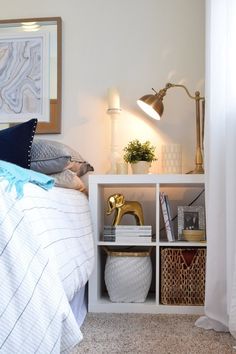 a bedroom with a bed, lamp and bookshelf in the corner next to it