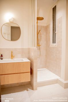 a bathroom with a sink, mirror and bathtub in the shower area is shown