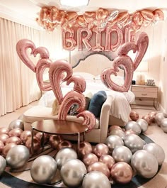 a room filled with balloons and furniture in the shape of heart shaped letters that spell out bride