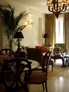 a living room filled with furniture and a chandelier hanging from the ceiling next to a window