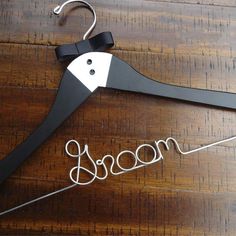 a black and white wooden hanger with the word broom on it's side