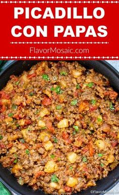 a skillet with meat and potatoes in it on top of a green table cloth