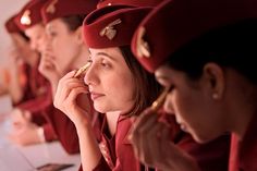 a group of women in red uniforms sitting at a table with pens and pencils