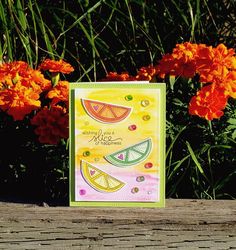 a card with watermelon slices on it and orange flowers in the back ground