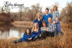 a family posing for a photo in front of a lake