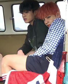 two people sitting in the back of a van with red hair and plaid shirts on