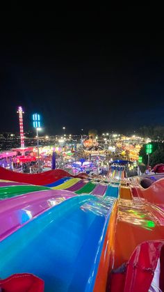 an amusement park at night with colorful slides