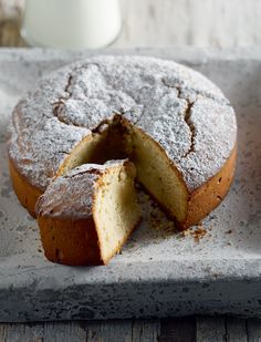 a cake that has been cut in half and is on a tray next to a glass of milk