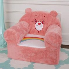 a pink teddy bear chair sitting on top of a rug in a child's room