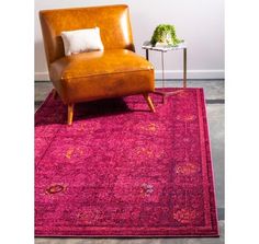 a pink rug with a brown leather chair and side table next to it on the floor