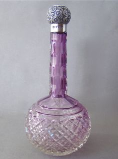 a purple glass bottle sitting on top of a table