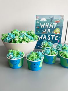 blue and green cupcakes in front of a book with what is waste written on it