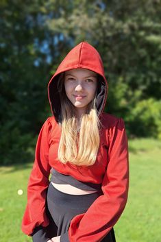 a girl in a red hoodie posing for the camera with her hands on her hips