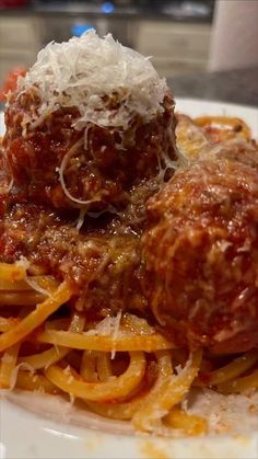 spaghetti and meatballs on a plate with parmesan cheese