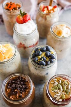 four jars filled with different types of desserts and toppings on top of a table