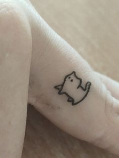 a small cat tattoo on the foot of a person's left foot, which is black and white