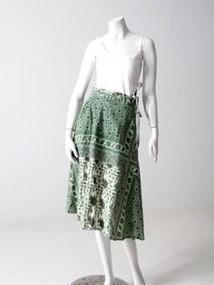 "This is a 1970s vintage wrap skirt. The all cotton skirt features a green, black and cream block floral print. It wraps closed with long ties and belt loops. A rare style with pockets at the waist! CONDITION In good condition with wear consistent with age and use. APPPROXIMATE FIT: S/M MEASUREMENTS Fits Waist Best: 26\" - 30\" .. 33 cm - 76.2 cm Waistband open: 35.5\" ... 90.2 cm Ties each: 27\" ... 68.6 cm Length: 29\" ... 73.7 cm HOW WE MEASURE * Skirt measured lying flat * Waistband open mea Green Bohemian Wrap Skirt For Spring, Bohemian Green Long Wrap Skirt, Green Bohemian Long Wrap Skirt, Green Cotton Wrap Skirt For Spring, Spring Green Cotton Wrap Skirt, Green Block Print, Hippie Boots, Boho Green, Vintage Clothing Online