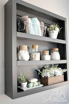 the bathroom shelves are decorated with white flowers and succulents in vases