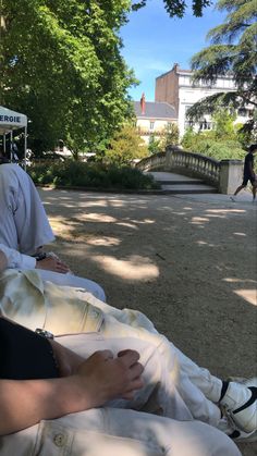 two people sitting on the ground in front of trees