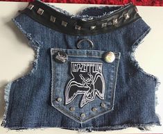 an old pair of jean shorts with patches and studs on the side, hanging from a wall