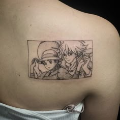 the back of a woman's shoulder with an image of two anime characters on it