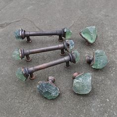 several pieces of glass sitting on the ground next to some metal handles and knobs