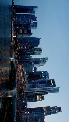 an airplane flying in the sky over some tall buildings