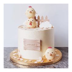 a cake with two chickens on top of it and a wooden fence in the background