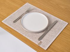 a white plate and silverware sitting on top of a wooden table