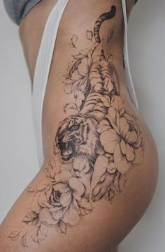 a woman's thigh with a tiger and flowers on it