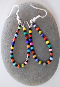 this is a handmade pair of rainbow beaded earrings. Colorful Tiny Beads Dangle Earrings, Rainbow Dangle Beaded Earrings Handmade, Rainbow Handmade Beaded Dangle Earrings, Beaded Rainbow Drop Earrings, Handmade Rainbow Beaded Dangle Earrings, Multicolor Tiny Beads Drop Earrings, Colorful Dangle Earrings With Tiny Beads, Rainbow Dangle Earrings With Tiny Beads, Colorful Czech Glass Round Beaded Earrings