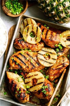 grilled chicken with pineapple slices and onions in a pan