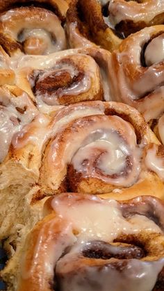 cinnamon rolls with icing sitting on top of each other