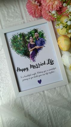 a white frame with a photo and flowers next to it that says happy married life