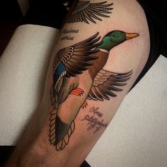 a tattoo on the leg of a man with a duck