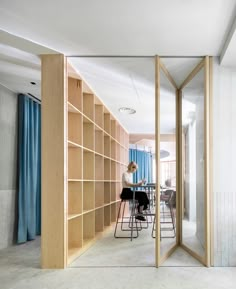 a person sitting at a table in front of a book shelf