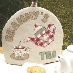 there is a tea pot and cookie on the table with it's name written