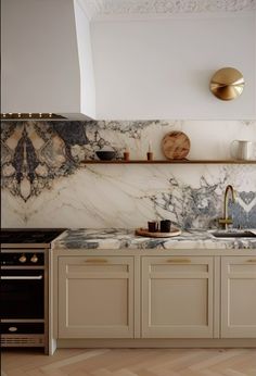 a kitchen with marble counter tops and gold faucets on the wall above it