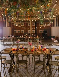 tables and chairs are set up for an event with lights hanging from the ceiling above them