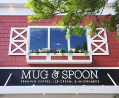 the sign for mug & spoon coffee in front of a red building with white windows